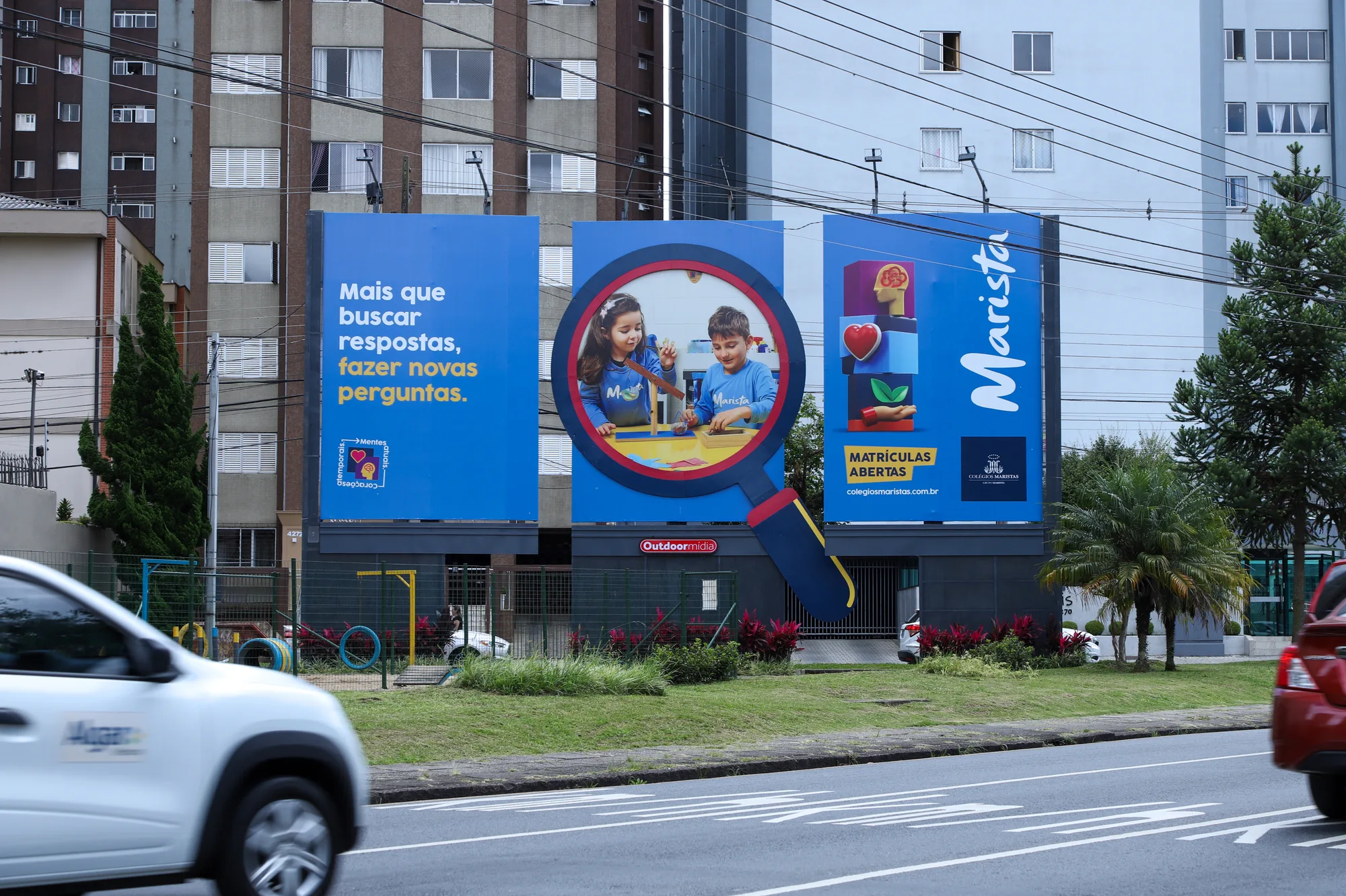Estrutura de três outdoors à beira de avenida em Curitiba inteiramente ocupada pela campanha de matrículas do Colégio Marista