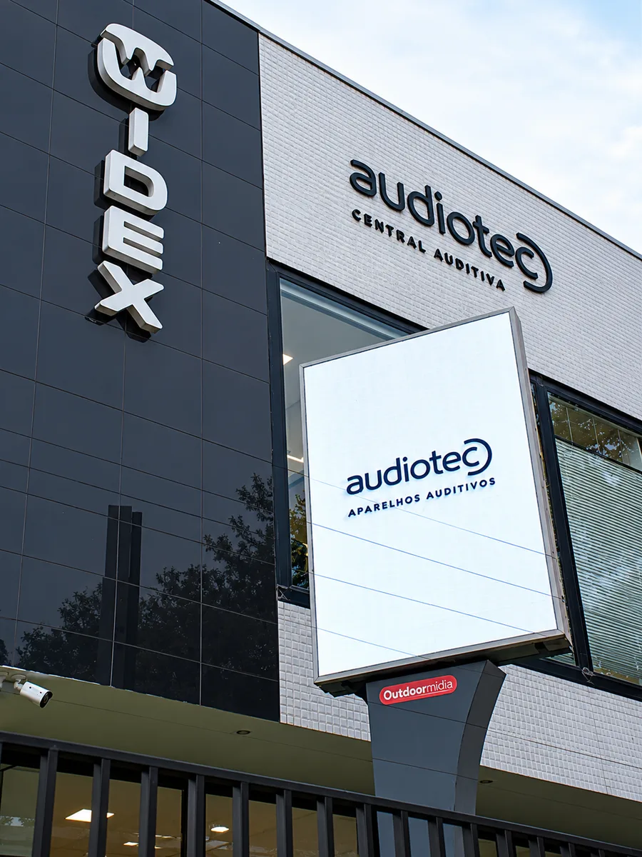 Painel de LED vertical da Outdoormídia na fachada da Audiotec, exibindo a marca da loja