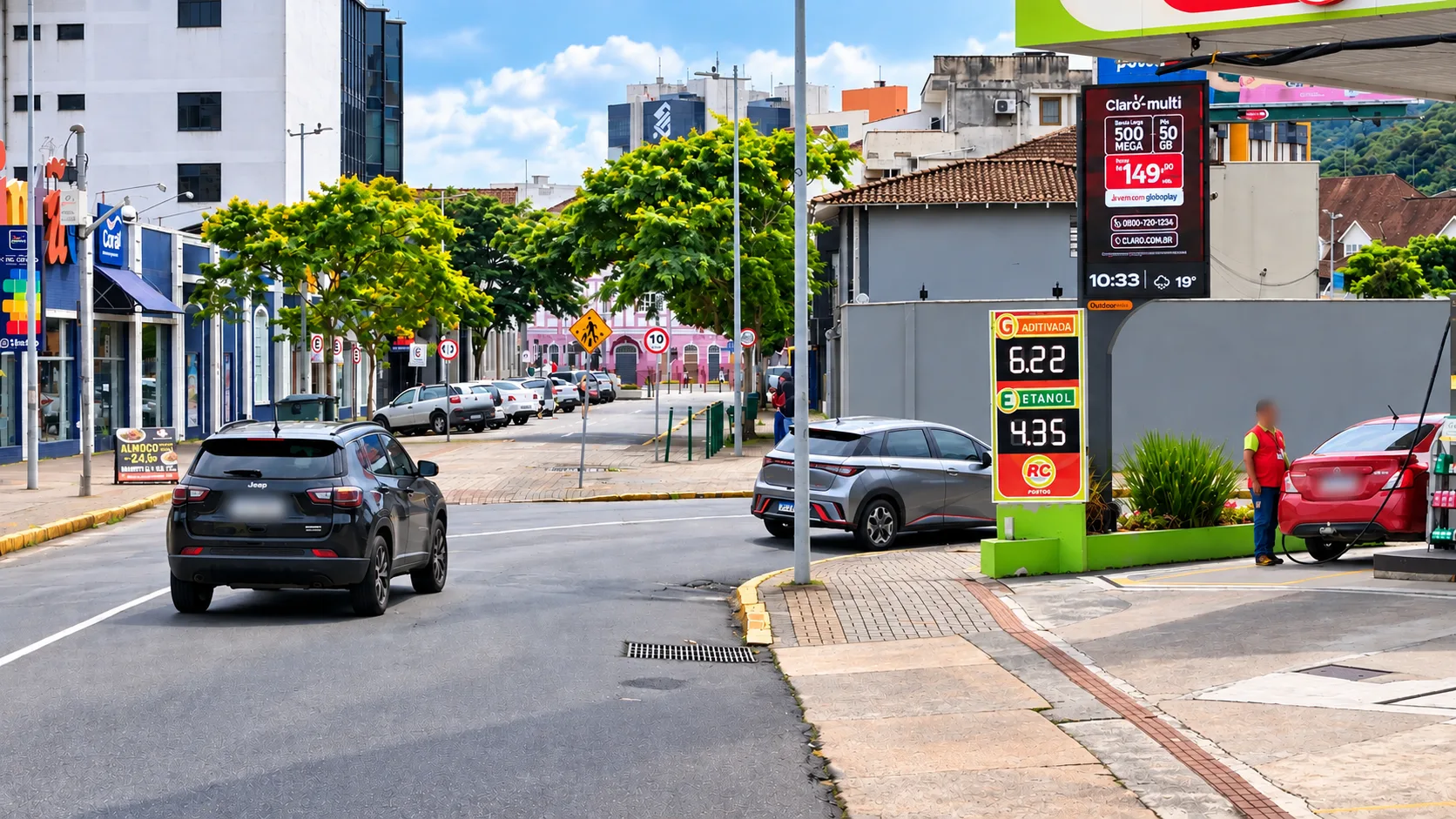 Painel de LED da Outdoormídia na área de abastecimento de um posto de combustível, ao lado do totem de preços