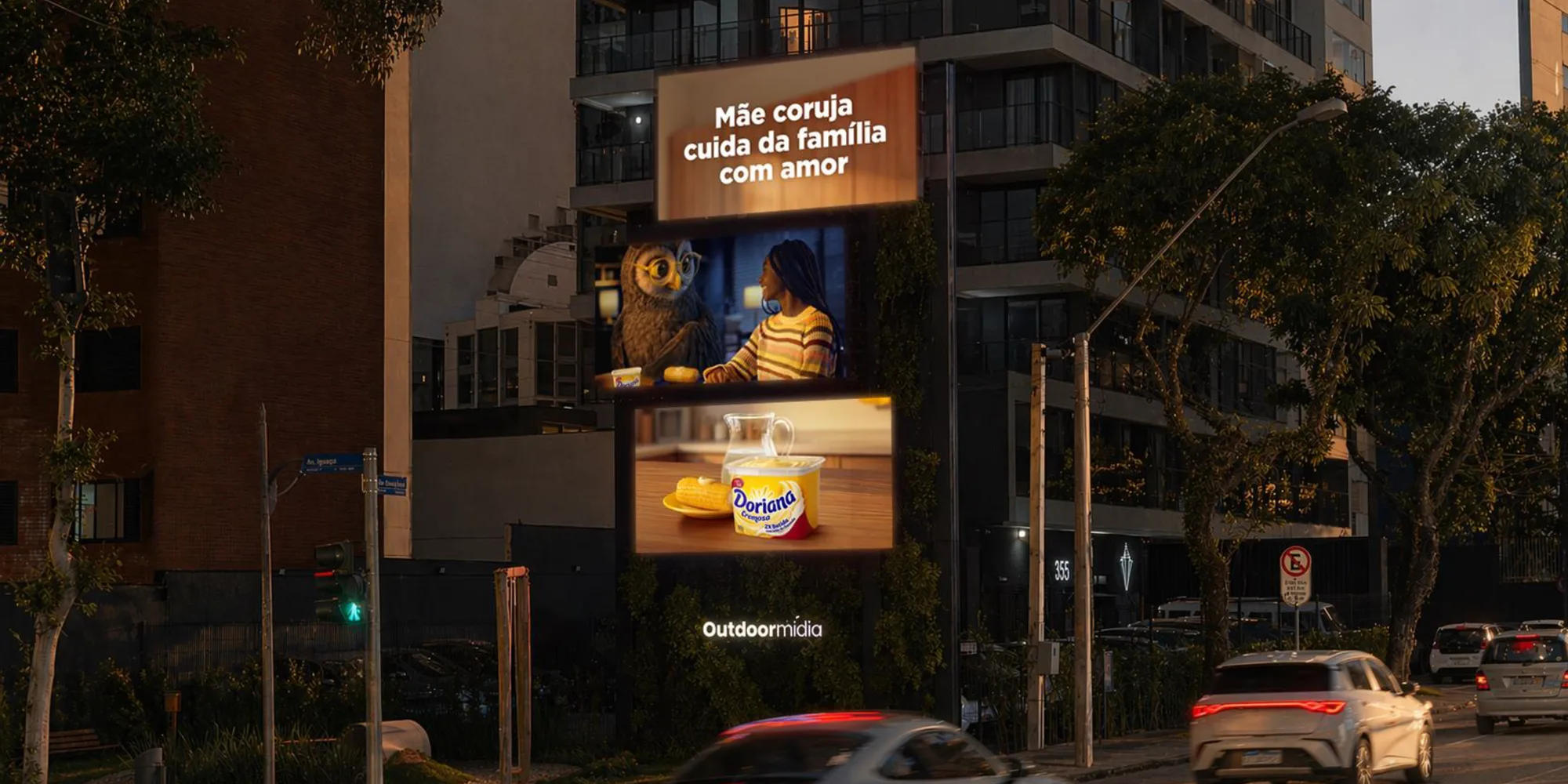Painel digital vertical na fachada de um edifício, em rua arborizada