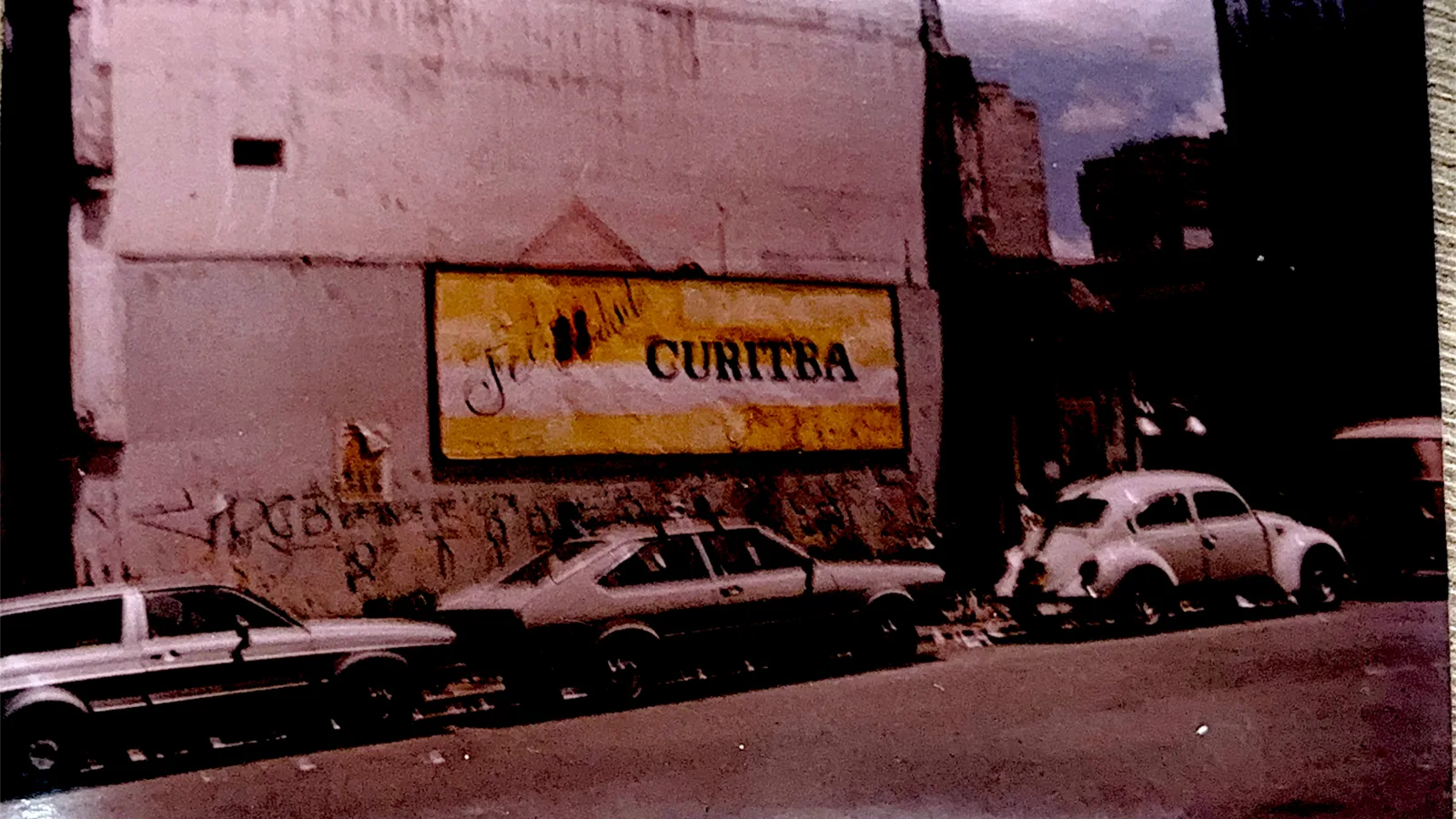 Painel pintado na parede com o nome Curitiba, rua da capital nos anos 1980.
