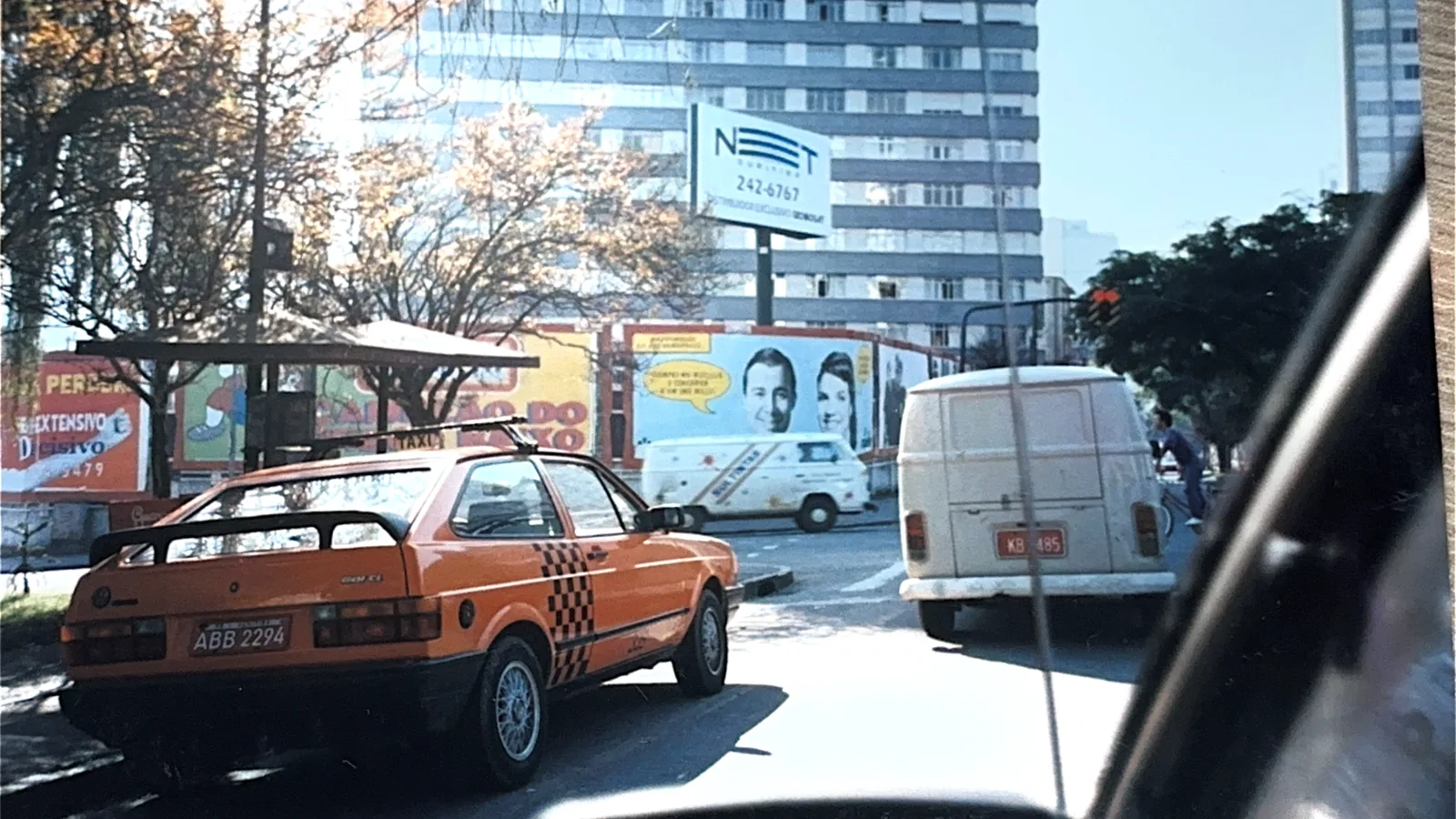 Painéis publicitários em ponto de ônibus movimentado de Curitiba nos anos 2000.