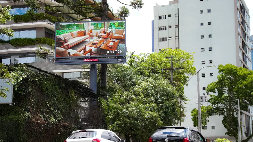 Painel Poster Sight digital da Outdoormídia com campanha da Breton, entre prédios de Curitiba