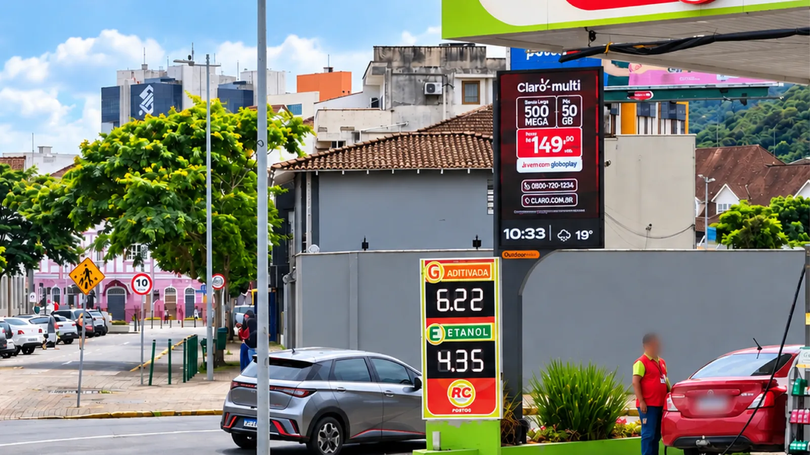 Relógio Digital da Outdoormídia exibindo campanha da Claro, hora e temperatura em posto de combustível
