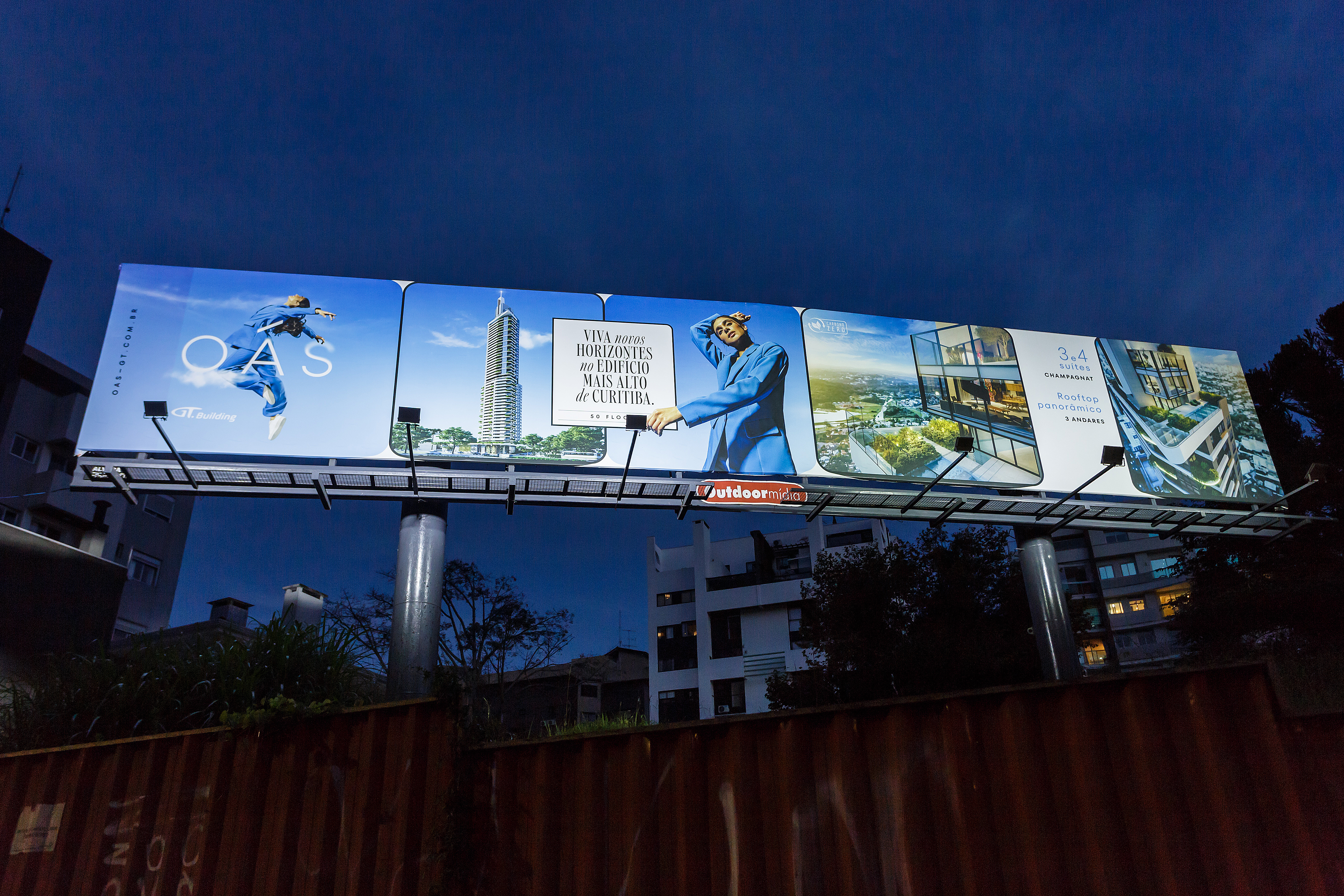 Super Billboard da Outdoormídia iluminado ao anoitecer, com campanha do edifício OAS