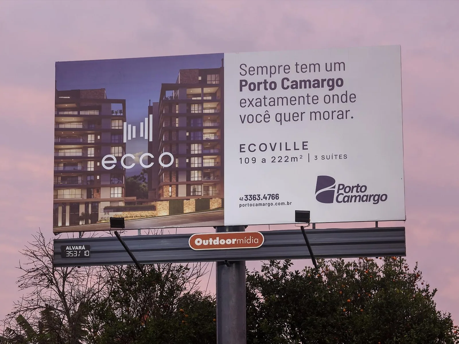 Painel Top Sight estático da Outdoormídia com campanha da Unimed Curitiba, entre árvores à beira de via