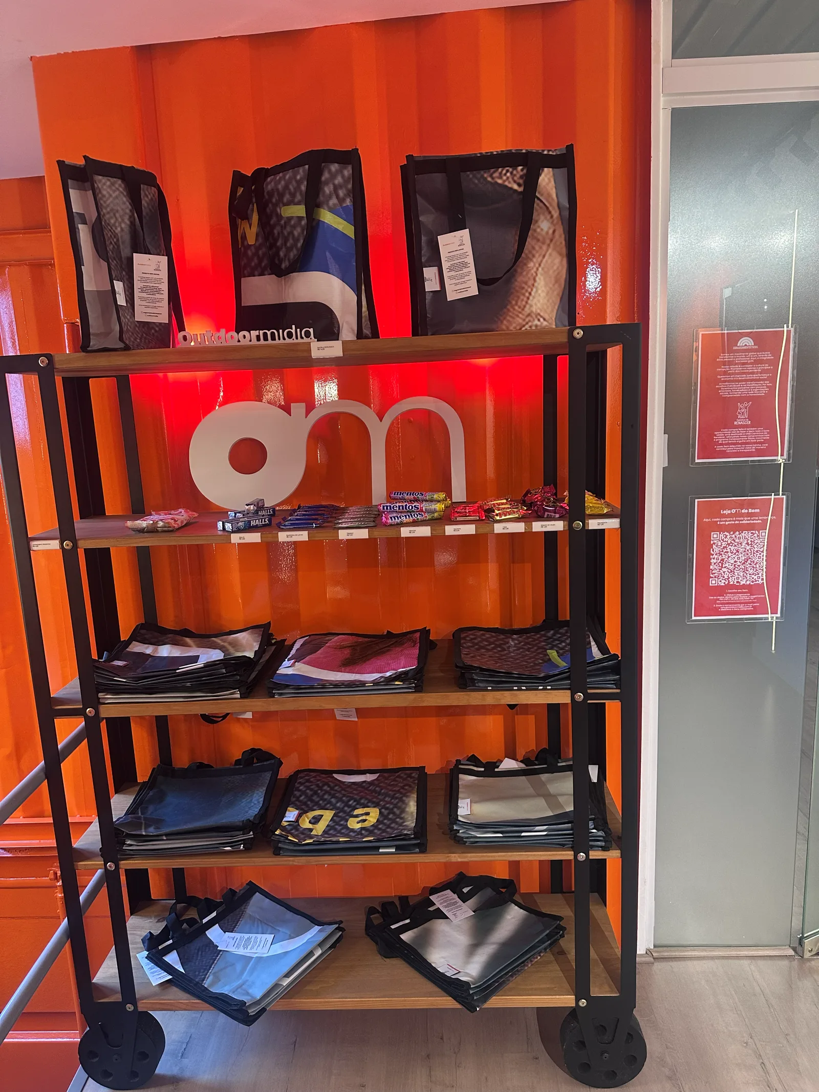 Prateleiras da Loja OM do Bem, com ecobags feitas de lona reaproveitada